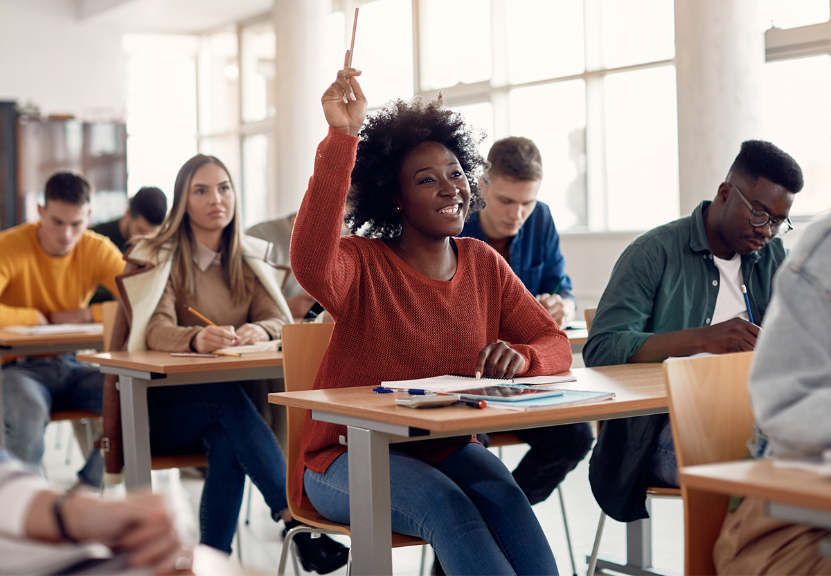 woman raising her hand in class
